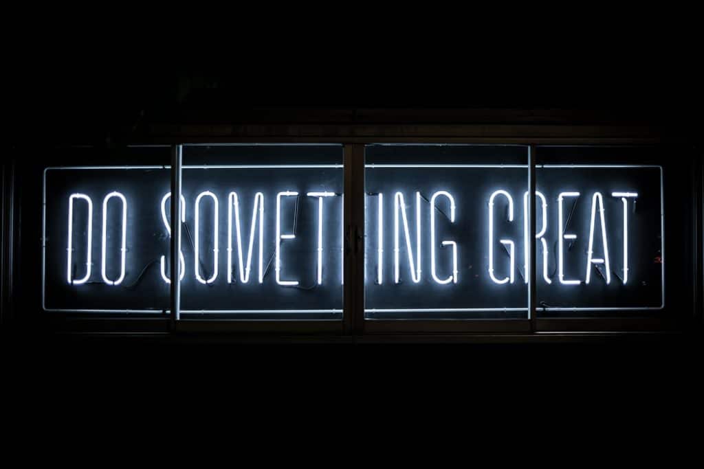 Fundo preto com luz em neon escrito "do something great"
