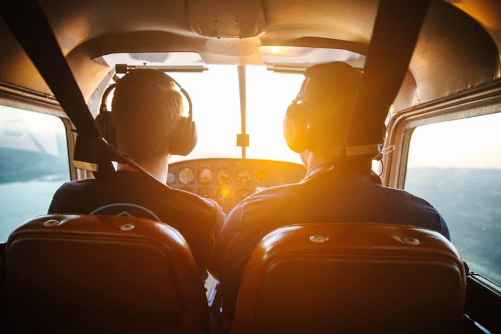 Dois homens pilotando avião durante o dia